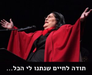 מרסדס סוסה על במה בגלימה אדומה, פורשת זרועות מול מיקרופון, למטה הכיתוב תודה לחיים שנתנו לי הכל