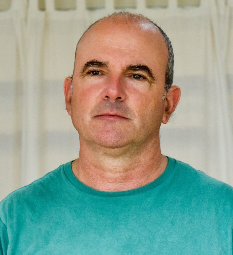 דיוקן של גבר לבוש בחולצת טורקיז על רקע לבן